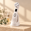Lift 5-in-1 RF & LED firming device in Pearl White on a travertine stone, soft evening light