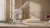 AURA spa devices on a travertine vanity with rising steam